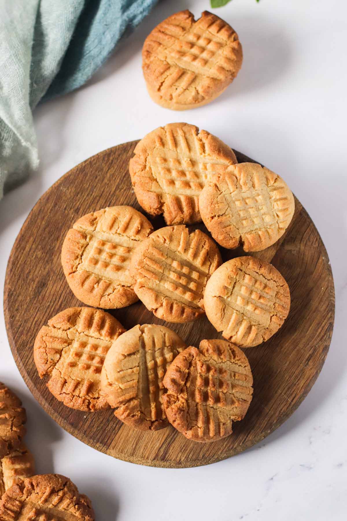 top view of peanut butter cookies on a round wooden tray.